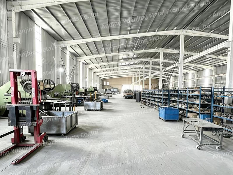 Wire mesh factory workshop with production equipment and storage racks